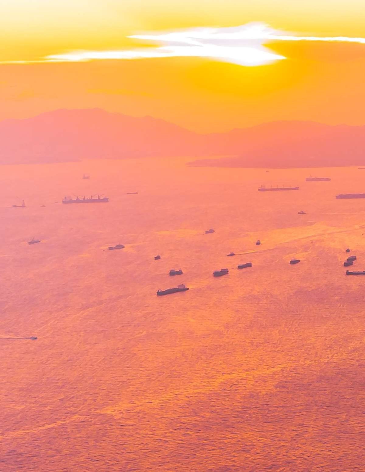 Tankers at anchor offshore at sunset
